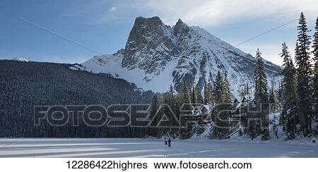 Stock Photograph - Walking in the snow on frozen Lake Louise; Lake Louise, Alberta, Canada. Fotosearch