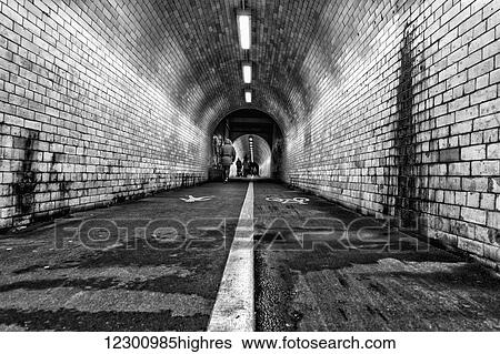 Stock Photograph - White line down the middle of a dirty, worn pedestrian and cycling tunnel; York, Yorkshire, England. Fotosearch