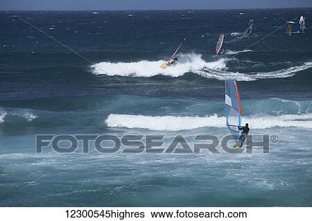 Stock Photograph - Wind surfers and sail boarders at Ho'okipa Beach, on the road to Hana; Paia, Maui, Hawaii, United States of America. Fotosearch