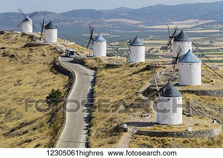 Stock Photograph - Windmills in a row along a road; Consuegra, Spain. Fotosearch
