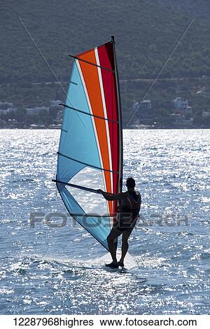 Windsurfing with sunlight reflected on the water and a view of the shoreline; Turkey View Large Photo Image Stock Photograph - Windsurfing with sunlight reflected on the water and a view of the shoreline; Turkey. Fotosearch