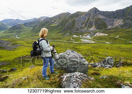 Woman photographs the old mine buildings of Independence Mine in Hatcher Pass up the trail to Gold Cord Lake, Alaska in Summer. Southcentral Alaska. View Large Photo Image Stock Photograph - Woman photographs the old mine buildings of Independence Mine in Hatcher Pass up the trail to Gold Cord Lake, Alaska in Summer. Southcentral Alaska.. Fotosearch