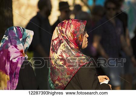 Stock Photograph - Women in a crowd near Blue Mosque wearing colourful headscarves; Istanbul, Turkey. Fotosearch