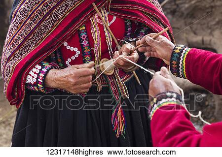 Stock Photograph - Women spinning wool from fleece in Amaru community of Sacred Valley, near Urubamba; Cusco, Peru. Fotosearch