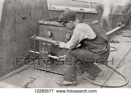 Worker using a Thor Pneumatic drill, the photograph shows the utility of the drill when working in a corner. From The Romance of the Merchant Ship, published 1931. View Large Photo Image Stock Photo - Worker using a Thor Pneumatic drill, the photograph shows the utility of the drill when working in a corner. From The Romance of the Merchant Ship, published 1931.. Fotosearch