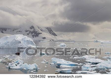 Stock Image - Zodiac among icebergs in Neko Harbor, Antarctic Peninsula; Antarctica. Fotosearch