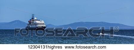 Stock Photograph - Zodiac heads towards cruise ship in sunshine; Antarctica. Fotosearch