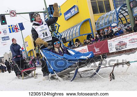 Zoya DeNure and team leave the ceremonial start line with an Iditarider during the 2016 Iditarod View Large Photo Image Stock Photograph - Zoya DeNure and team leave the ceremonial start line with an Iditarider during the 2016 Iditarod. Fotosearch