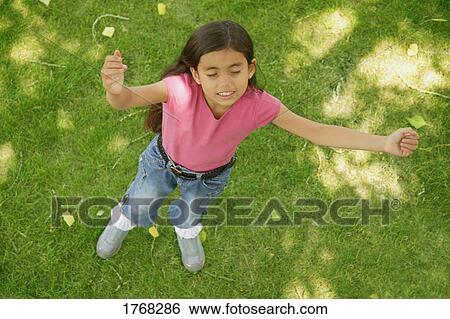 Stock Photograph - Child with arms raised. Fotosearch
