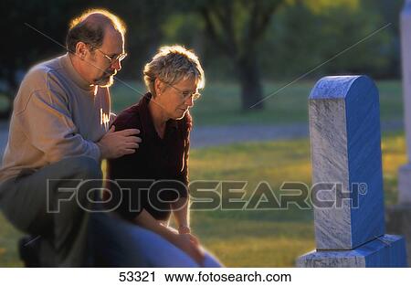 Stock Image - Couple visiting grave. Fotosearch