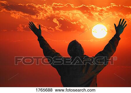 Stock Photo - Man lifts hands towards the heavens. Fotosearch