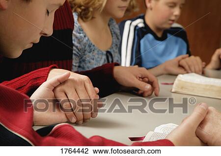 Stock Image - Small group prayer. Fotosearch