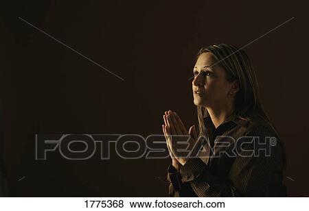 A woman in prayer View Large Photo Image Stock Photo - A woman in prayer. Fotosearch