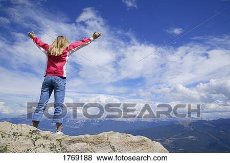 Stock Photo - Praising God from the top of a mountain. Fotosearch