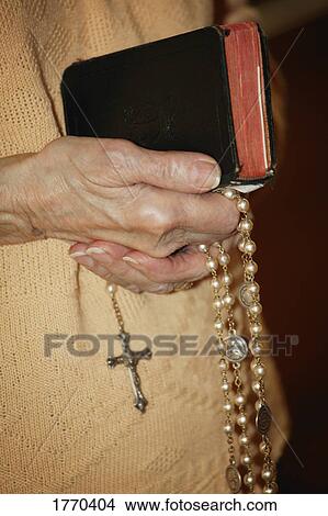 Rosary beads and bible held View Large Photo Image Picture - Rosary beads and bible held. Fotosearch