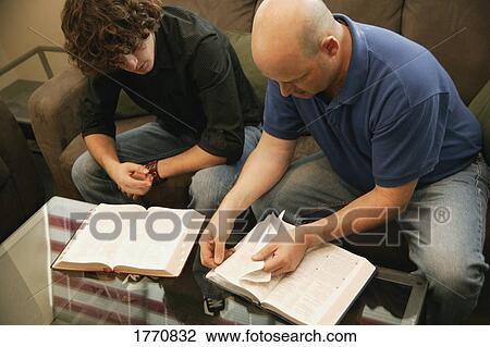 Stock Image - Two Males using reference books. Fotosearch