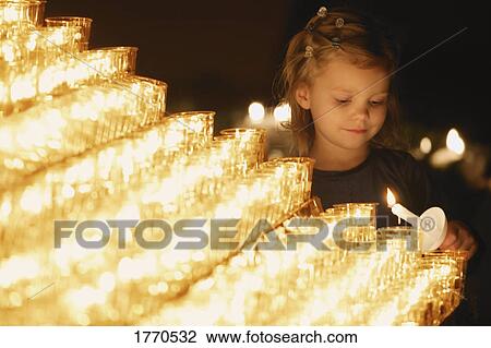 Young girl lighting a candle View Large Photo Image Stock Image - Young girl lighting a candle. Fotosearch