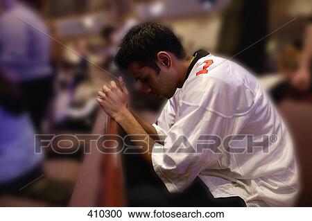 Young man praying in church pew View Large Photo Image Stock Image - Young man praying in church pew. Fotosearch