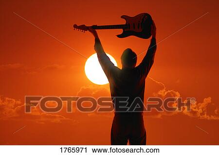 Stock Image - A man holding a guitar. Fotosearch