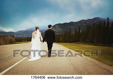 Bride and groom go for a walk View Large Photo Image Stock Photograph - Bride and groom go for a walk. Fotosearch
