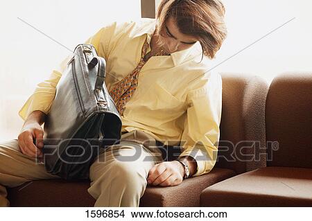 Picture - Man dozes in airport. Fotosearch