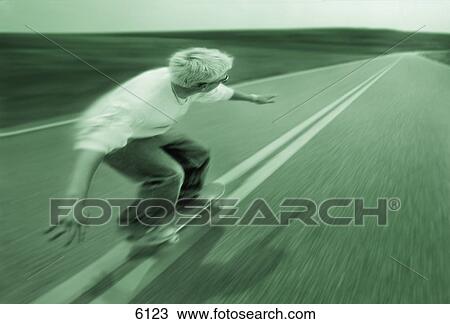 Teenager skateboarding down road View Large Photo Image Stock Image - Teenager skateboarding down road. Fotosearch