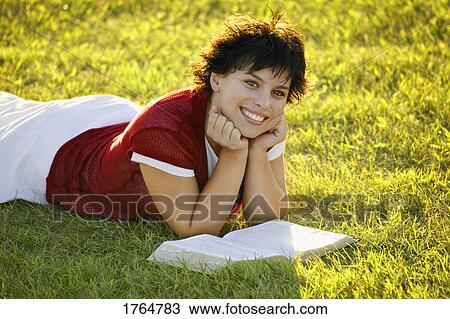 Stock Image - Young woman reads Bible. Fotosearch