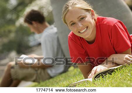 Picture - Blonde student reading outside. Fotosearch
