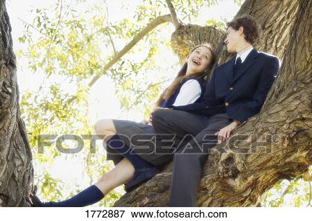 Couple hanging out in tree View Large Photo Image Stock Photo - Couple hanging out in tree. Fotosearch