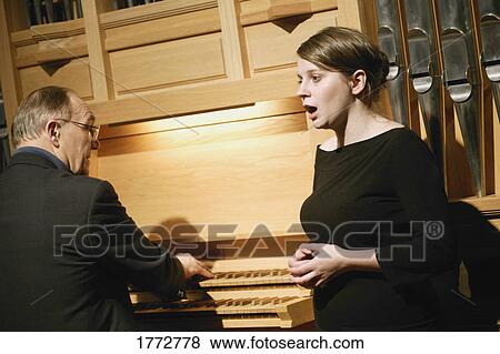 Singer being accompanied by an organist View Large Photo Image Stock Photo - Singer being accompanied by an organist. Fotosearch