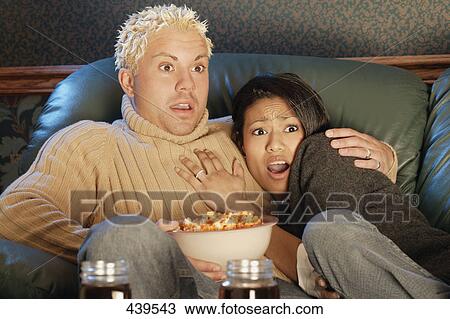 Stock Image - Couple watches a scary movie. Fotosearch