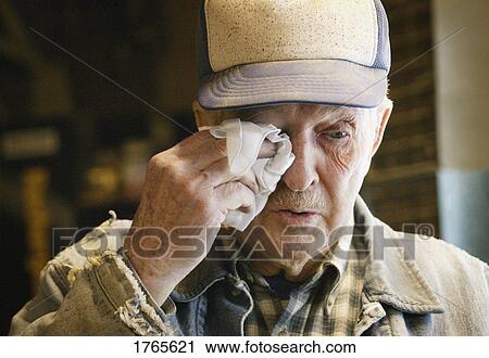 Stock Image - Senior wipes a tear away. Fotosearch