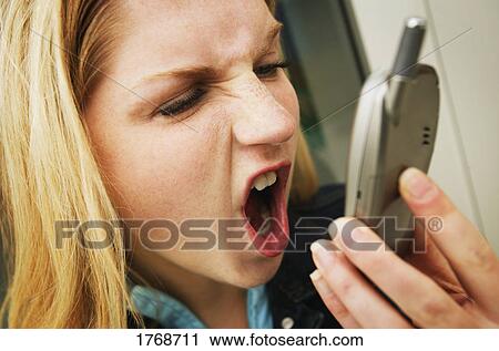 Shouting into cell phone View Large Photo Image Stock Image - Shouting into cell phone. Fotosearch
