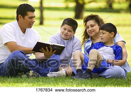 A family gathers around a book View Large Photo Image Picture - A family gathers around a book. Fotosearch