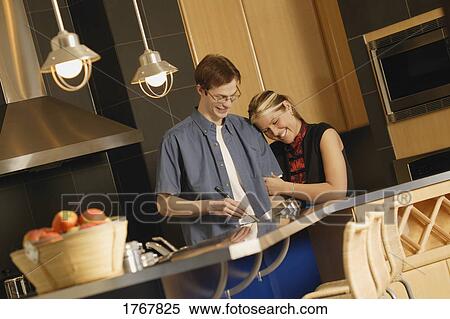 Couple cook together in kitchen View Large Photo Image Stock Photography - Couple cook together in kitchen. Fotosearch
