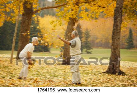 Stock Photograph - Couple throw leaves at each other. Fotosearch