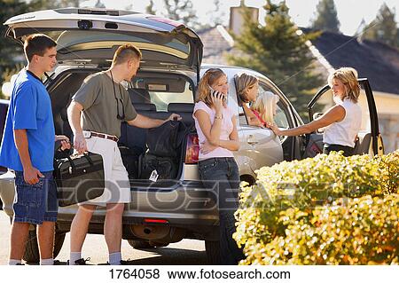Stock Photo - Family packs the car for a trip. Fotosearch