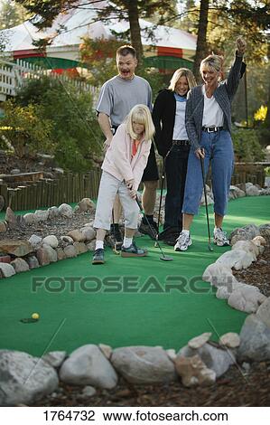 Stock Image - Family plays mini golf. Fotosearch