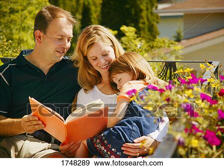 Family reads a book View Large Photo Image Stock Photo - Family reads a book. Fotosearch