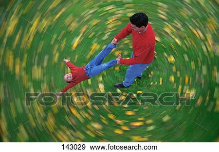 Man swinging child through air View Large Photo Image Stock Photo - Man swinging child through air. Fotosearch