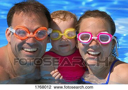 Stock Image - Portrait of Happy family in swimming pool. Fotosearch