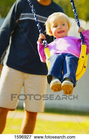 Toddler in a swing View Large Photo Image Stock Photo - Toddler in a swing. Fotosearch
