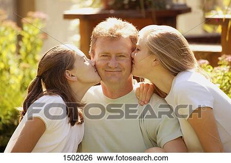 Stock Photograph - Two girls kiss father. Fotosearch