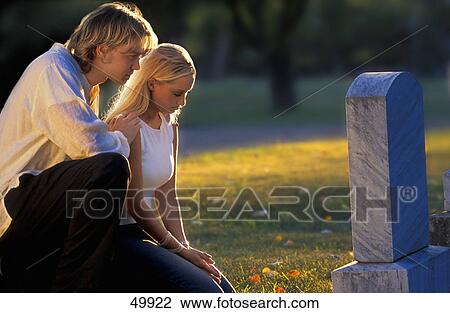 Stock Image - Visiting a grave. Fotosearch