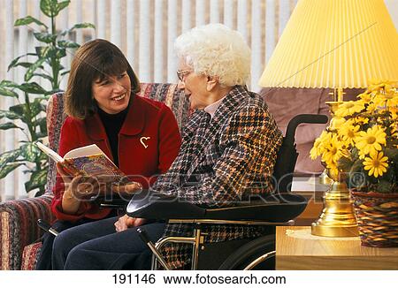 Woman reading to senior relative in wheelchair View Large Photo Image Stock Photograph - Woman reading to senior relative in wheelchair. Fotosearch
