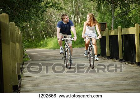 Couple on bikes View Large Photo Image Stock Photograph - Couple on bikes. Fotosearch
