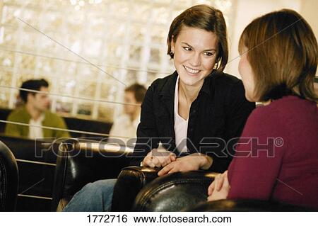 Two young women having a chat View Large Photo Image Stock Photograph - Two young women having a chat. Fotosearch