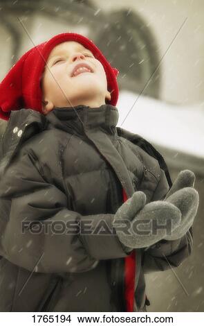 Picture - Child enjoys catching snowflakes. Fotosearch