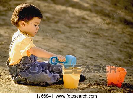 Stock Image - Child plays in the sand. Fotosearch
