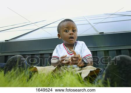 Child sitting on the grass View Large Photo Image Picture - Child sitting on the grass. Fotosearch